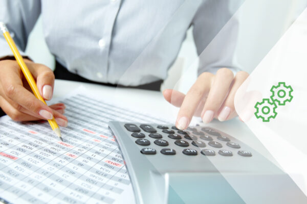 A nonprofit accountant typing on a calculator and flipping through financial reports.